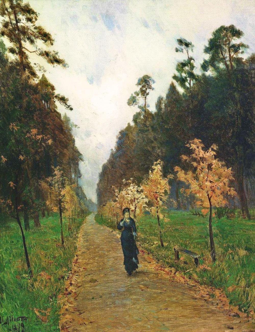 A woman in black walking alone down an autumn park path strewn with fallen leaves, under a grey sky.